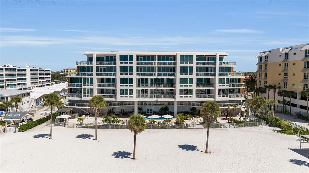 A white sign with the text Ten 35 Seaside stands in front of a modern building — 1035 SEASIDE DRIVE UNIT 308, SARASOTA, FL