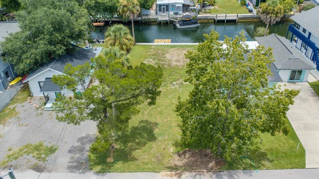An aerial view shows a vacant waterfront lot marked with a pink pin — 7250 COVENTRY COURT, WEEKI WACHEE, FL