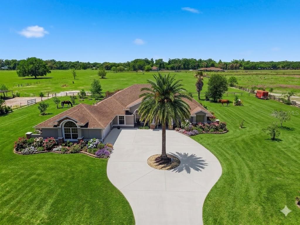 An aerial view of a single-story house with a palm tree and circular driveway — 12764 COUNTY ROAD 223, OXFORD, FL