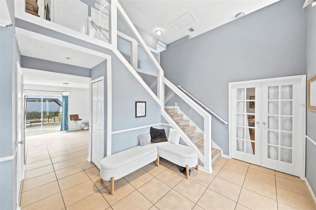 An entryway with tile floors, a white staircase, and a bench beneath the stairs — 1912 MAURY ROAD, ST CLOUD, FL