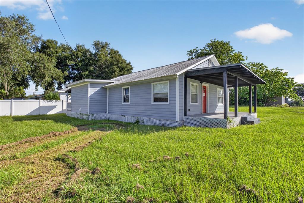 A light blue single-story house with a metal roof and a covered front porch — 4104 ORANGE AVENUE SE, HIGHLAND CITY, FL