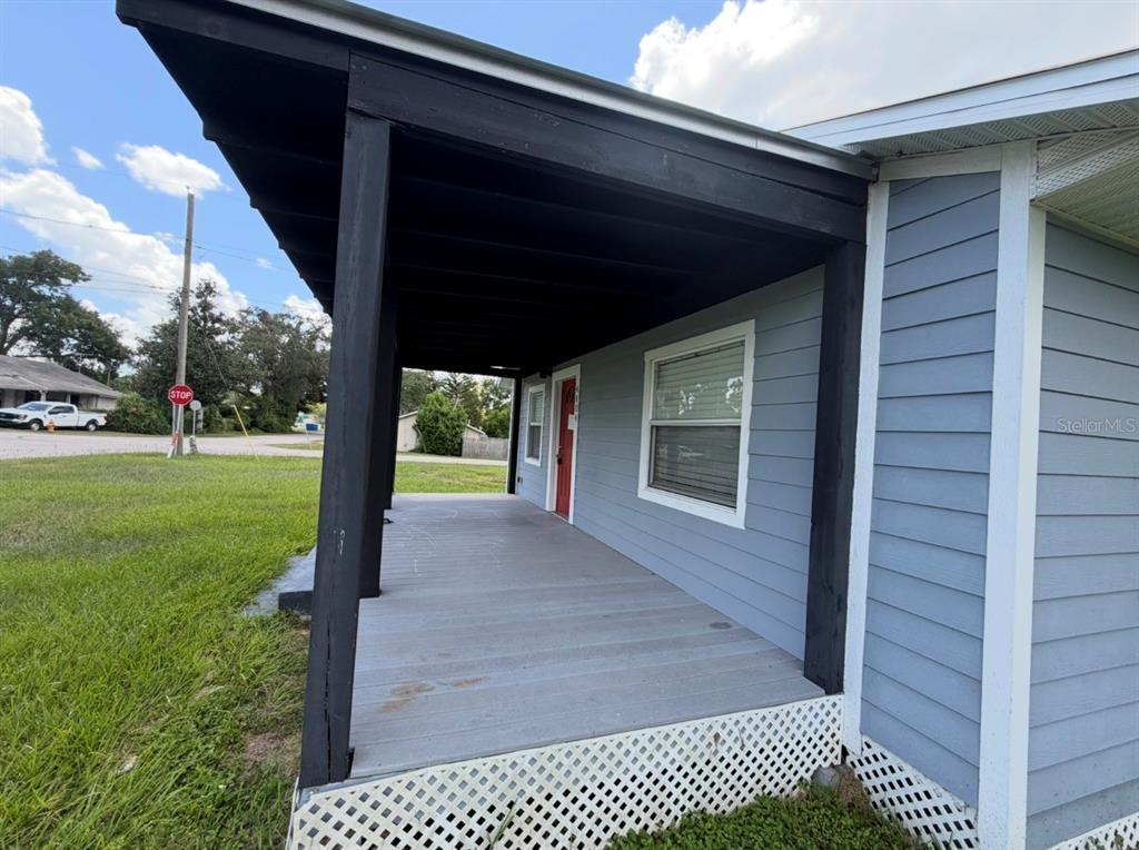 The exterior of a light blue house features horizontal siding, a window, and a small porch — 4104 ORANGE AVENUE SE, HIGHLAND CITY, FL