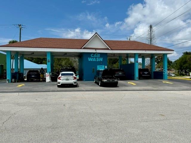 A blue car wash building with a brown roof stands in a paved parking lot — 598 S PARK AVENUE, TITUSVILLE, FL