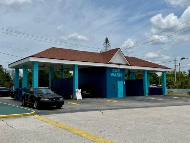 A blue car wash building with a brown roof stands in a paved parking lot — 598 S PARK AVENUE, TITUSVILLE, FL