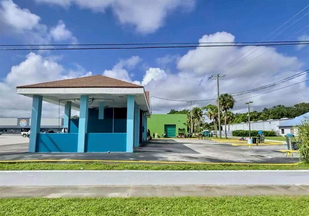 An exterior view of a blue car wash structure with a brown roof and parking area — 598 S PARK AVENUE, TITUSVILLE, FL