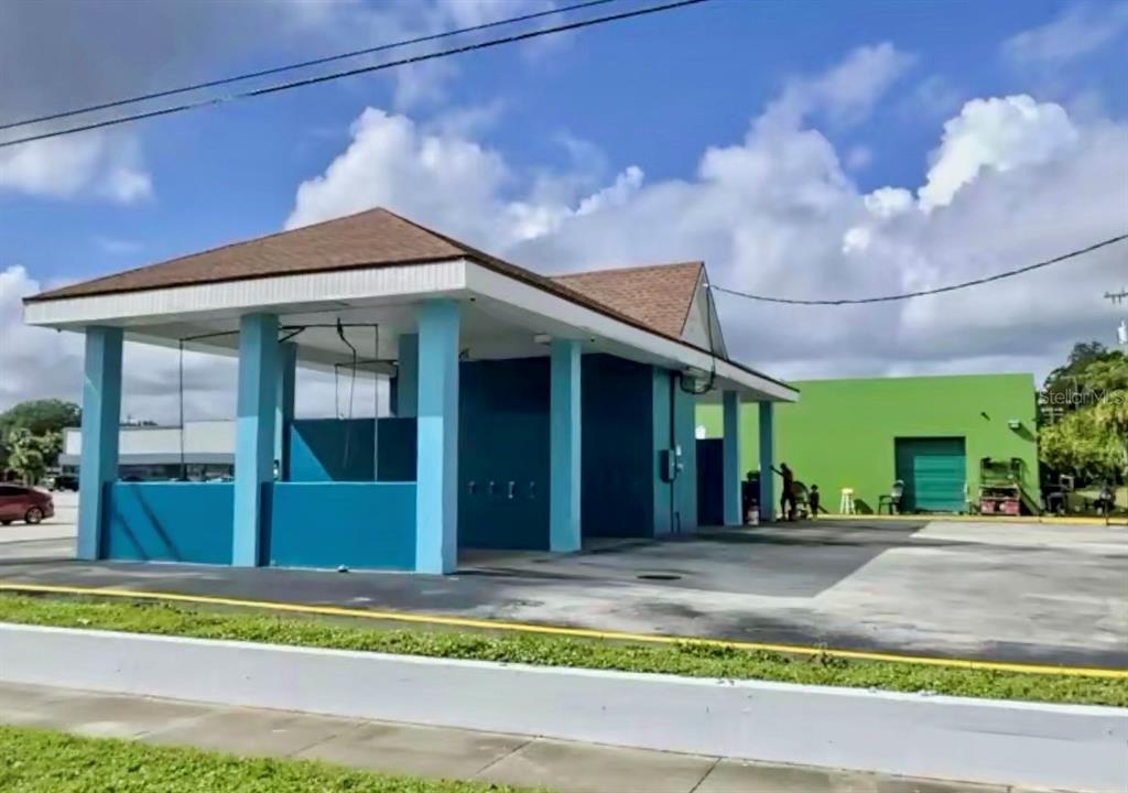 An exterior view of a blue car wash structure with a brown shingled roof — 598 S PARK AVENUE, TITUSVILLE, FL