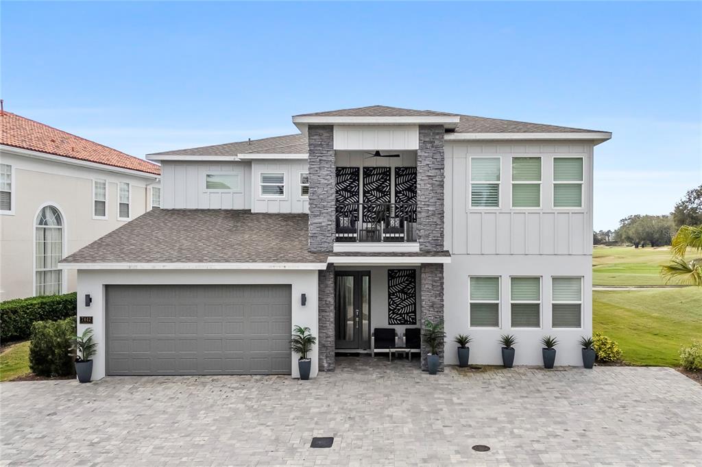 An aerial view shows two adjacent houses situated next to a golf course fairway — 7442 GATHERING COURT, KISSIMMEE, FL