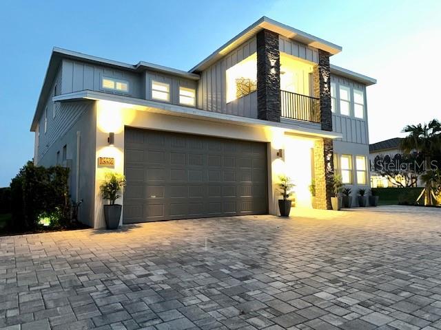 A two-story house with a stone-accented facade, a gray garage, and a paved driveway — 7442 GATHERING COURT, KISSIMMEE, FL