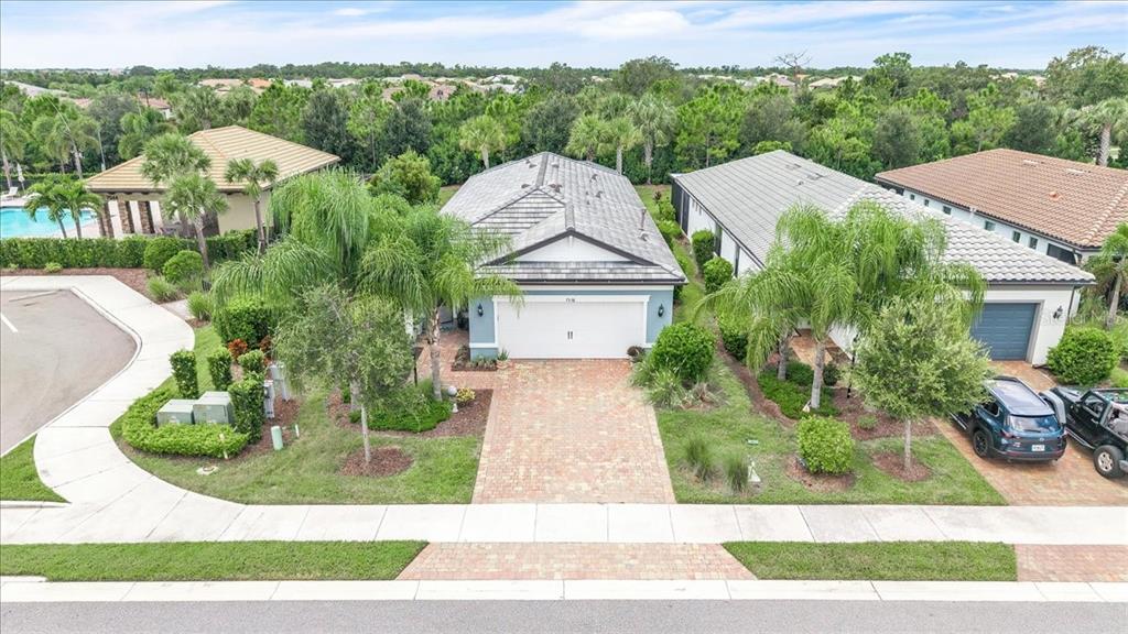 An aerial view of a suburban house with a brick driveway and a tiled roof — 7538 SUMMERLAND COVE, LAKEWOOD RANCH, FL