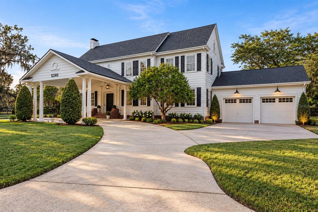 A two-story white house with black shutters and a large covered front porch entrance — 5240 ALLEMAN DRIVE, ORLANDO, FL