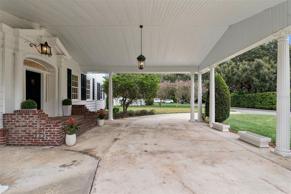 A covered driveway portico features white columns, a hanging lantern, and brick steps to a door — 5240 ALLEMAN DRIVE, ORLANDO, FL