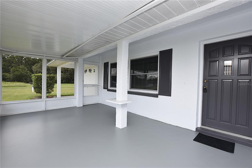 A covered porch with a gray floor, white walls, and a dark gray front door — 3602 BRUTON ROAD, PLANT CITY, FL