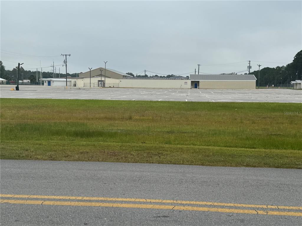 A large, paved parking lot sits in front of a long, single-story commercial building — 108 E MARKET ROAD, STARKE, FL