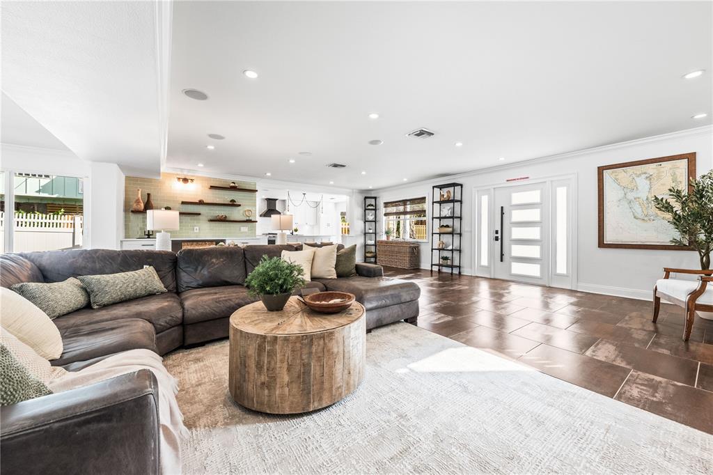 A living room features a large brown sectional, a wooden coffee table, and tile flooring — 550 N GULF BOULEVARD, PLACIDA, FL