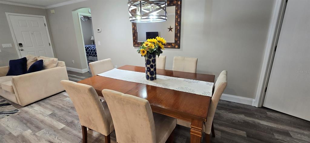 A dining room features a wooden table with six chairs and a floral centerpiece — 712 ARTESIA AVENUE, THE VILLAGES, FL