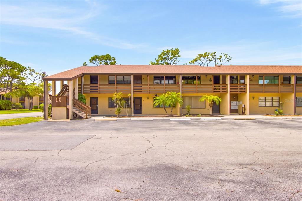 A two-story apartment building with a brown roof and a parking lot in front — 10 QUAILS RUN BOULEVARD UNIT 8, ENGLEWOOD, FL