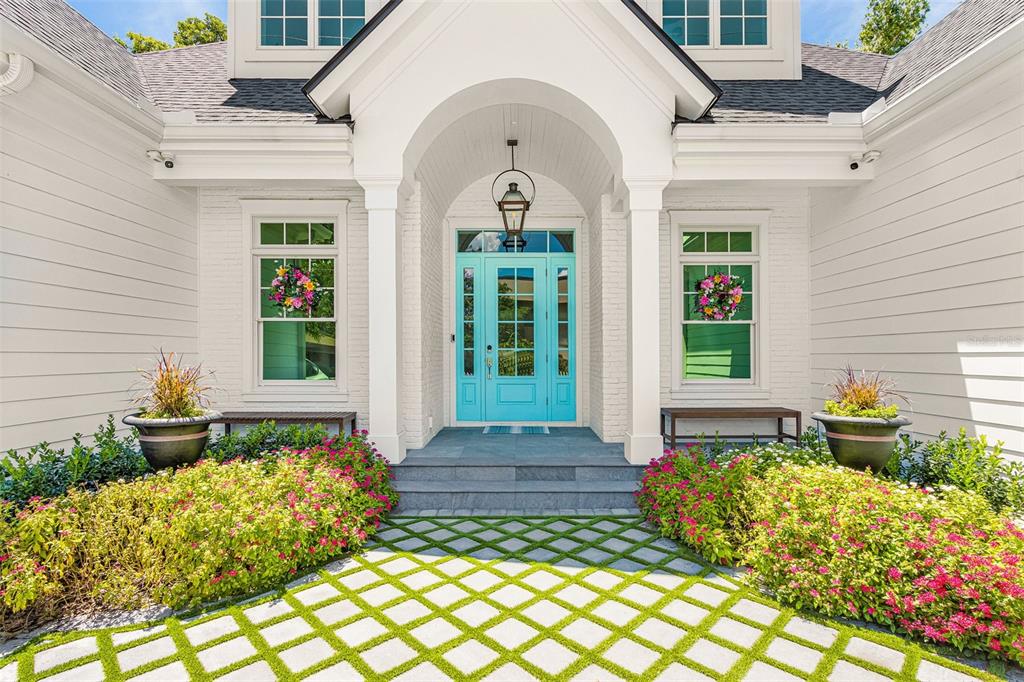 The exterior of a white house features a bright blue front door and stone walkway — 1426 S OSPREY AVENUE, SARASOTA, FL