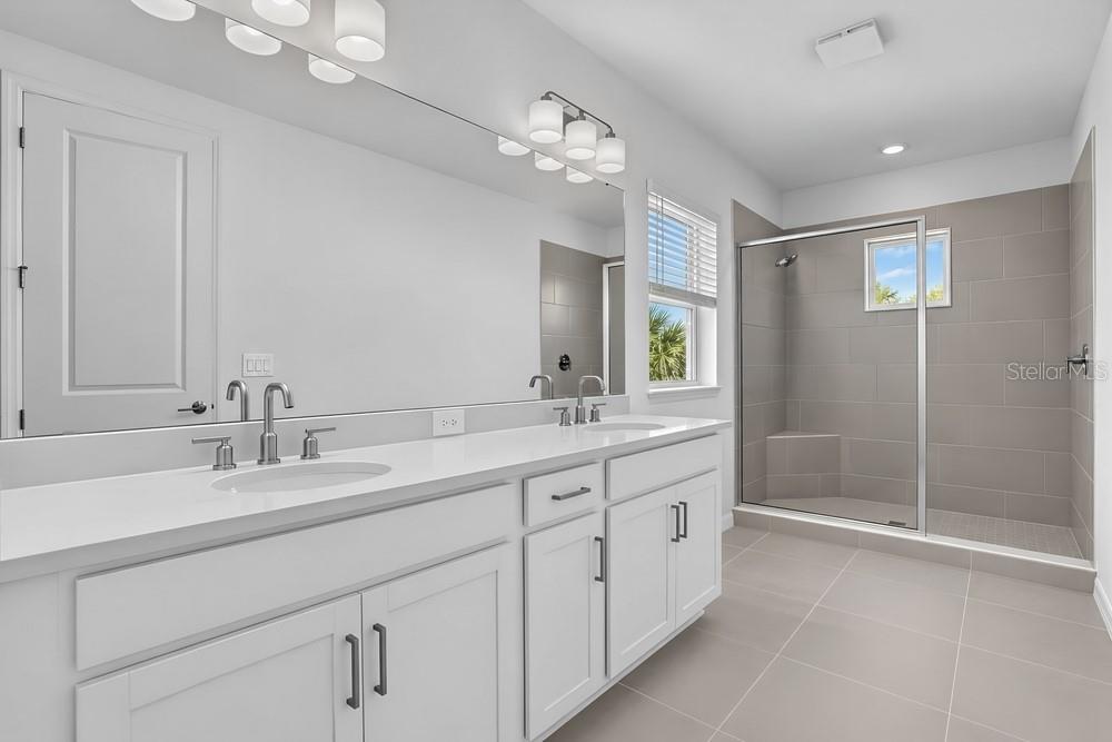 A modern kitchen with white cabinetry, a central island, and pendant lighting — 14258 SAWMILL STREET, PARRISH, FL