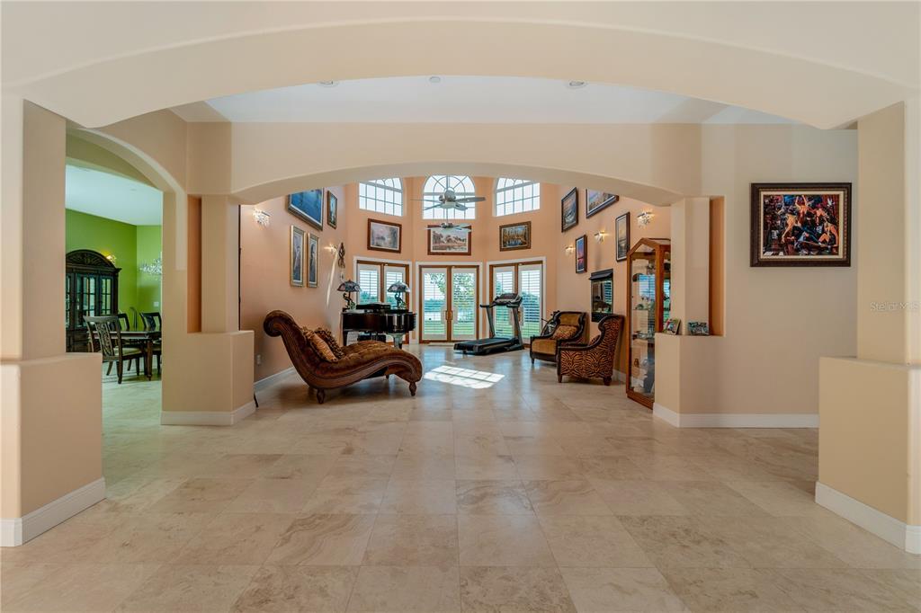 A spacious living area with tile floors, an arched entryway, and a view of the outdoors — 37511 WASHINGTON LOOP ROAD, PUNTA GORDA, FL
