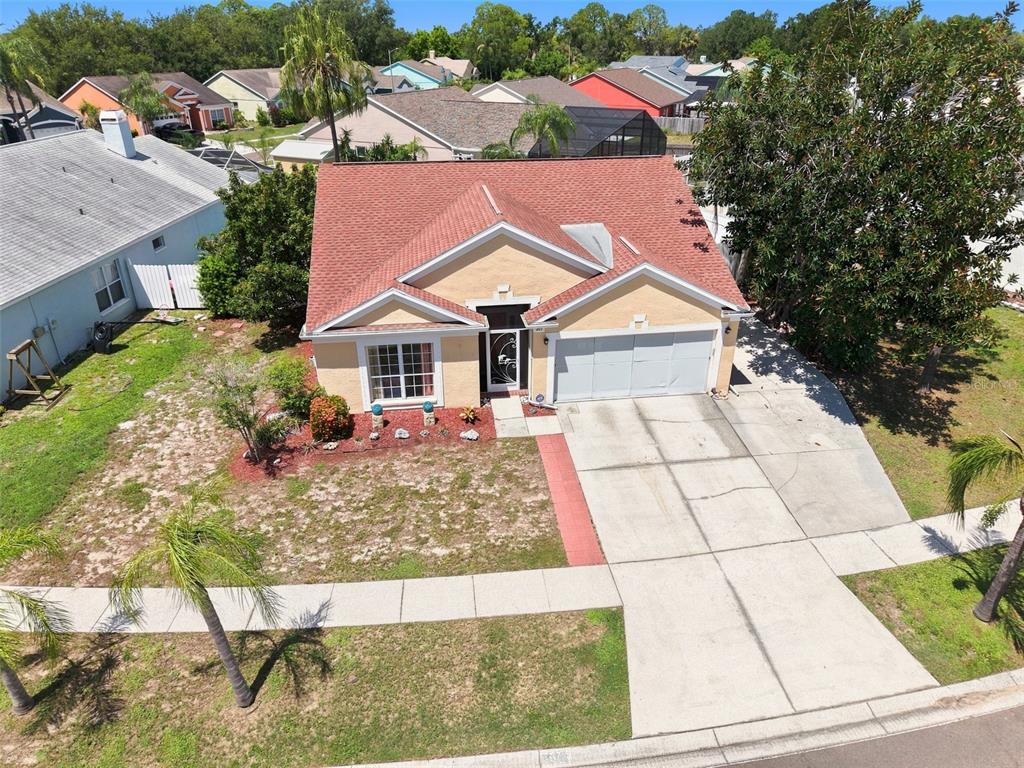 An aerial view of a single-story house with a red roof and a concrete driveway — 207 LAKEWAY LANE, APOLLO BEACH, FL