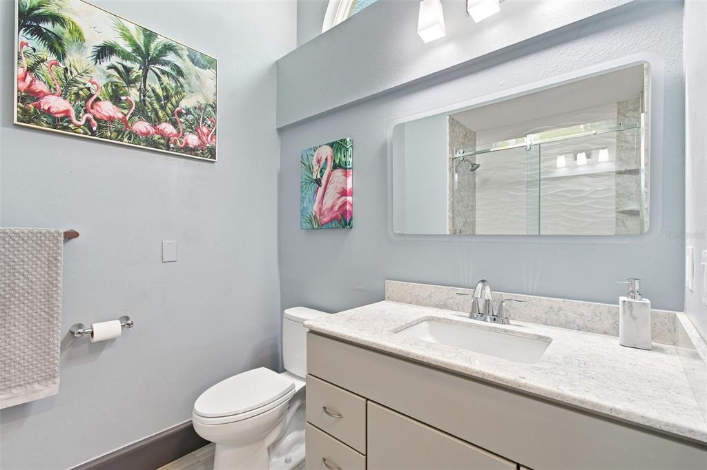 A bright foyer features high ceilings, a blue cabinet, a chandelier, and light-colored tile flooring — 16018 WILMINGTON PLACE, TAMPA, FL