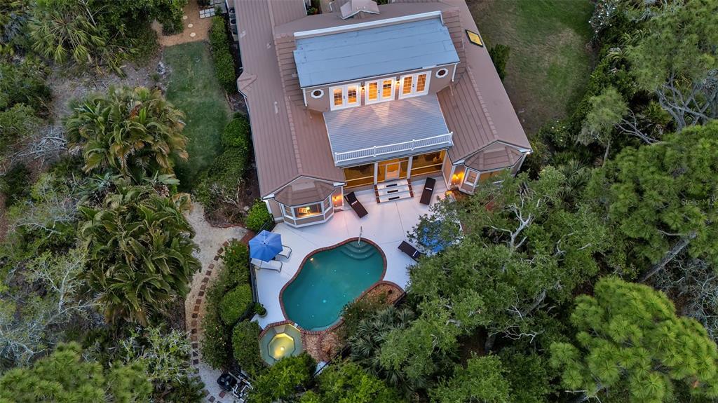 An aerial view shows a house with a pool, spa, patio, and surrounding landscaping — 156 BISHOPS COURT ROAD, OSPREY, FL