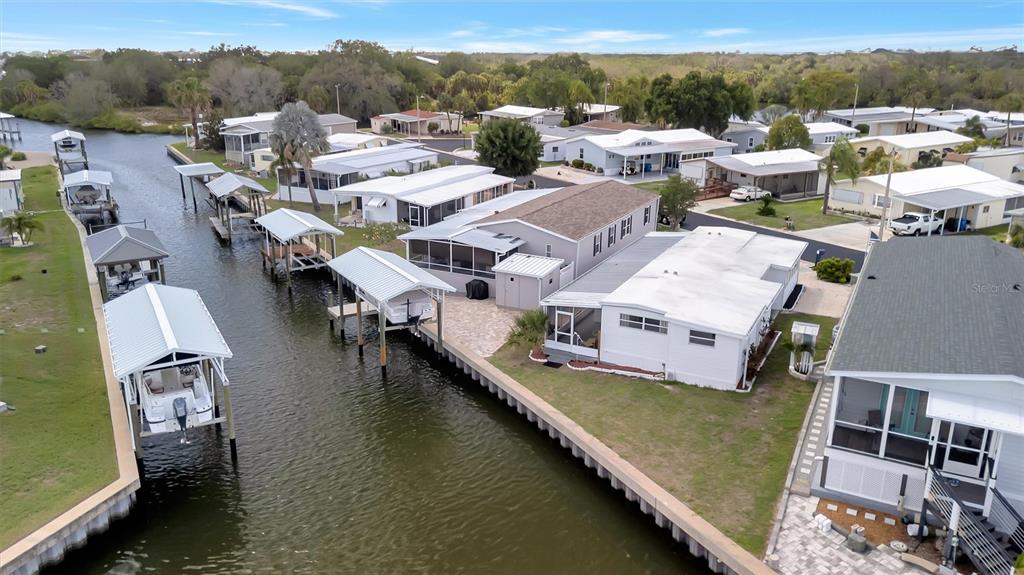 An aerial view shows several mobile homes with boat slips along a narrow canal — 162 S SAINT THOMAS CIRCLE, APOLLO BEACH, FL