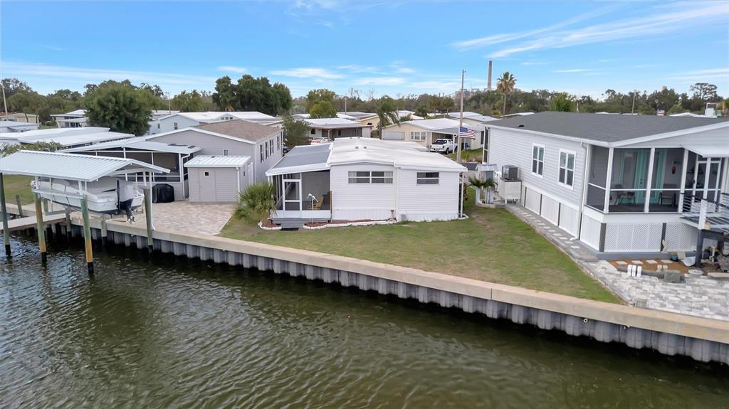 An aerial view shows several mobile homes situated along a canal with a boat lift — 162 S SAINT THOMAS CIRCLE, APOLLO BEACH, FL