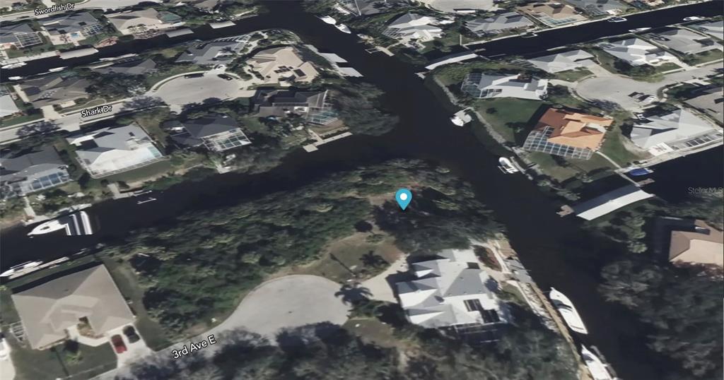 This aerial view shows a vacant waterfront lot situated at the intersection of two canals — 4623 3RD AVENUE E, BRADENTON, FL