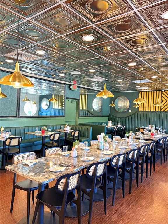 A restaurant dining room features a decorative metallic ceiling, green booth seating, and marble-topped tables — 7900 4TH ST N STREET, ST PETERSBURG, FL