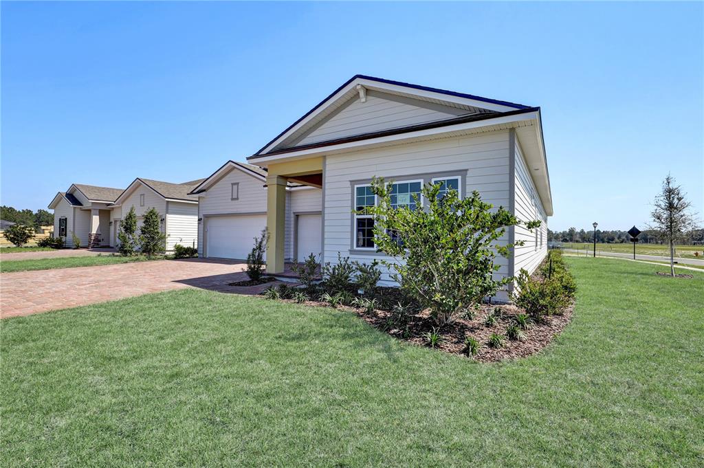 A light-colored single-story house with a brick driveway and a front-facing garage — 106 BRICKSTONE TRACE, ST AUGUSTINE, FL