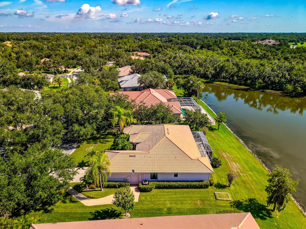 An aerial view of a suburban house with a tan roof next to a lake — 2012 ISLAND ESTATES DRIVE, PARRISH, FL