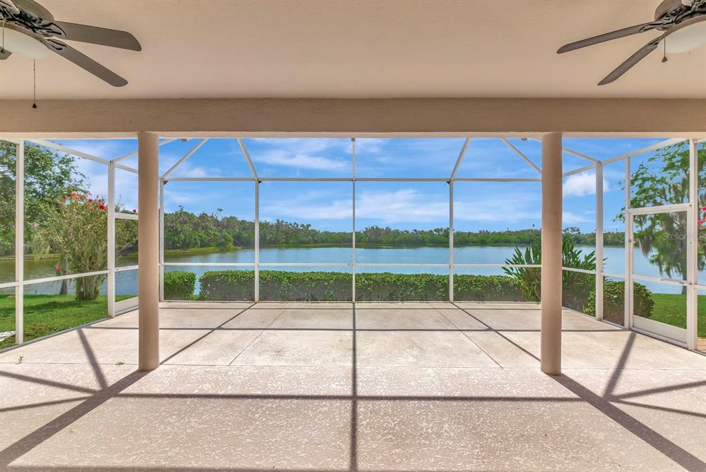 A screened-in patio with a concrete floor, two ceiling fans, and a view of a lake — 2012 ISLAND ESTATES DRIVE, PARRISH, FL