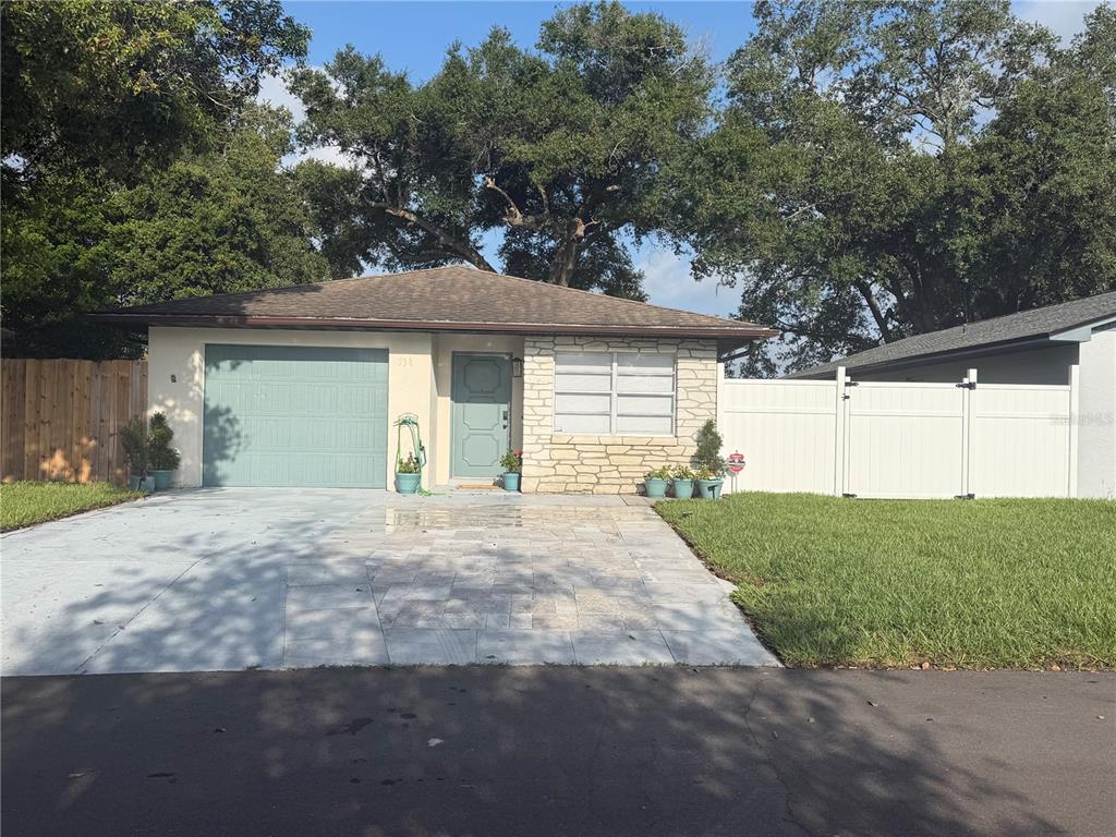 A single-story house features a stone facade, a gray garage door, and a paved driveway — 536 HIBISCUS WAY UNIT 7B, ORLANDO, FL