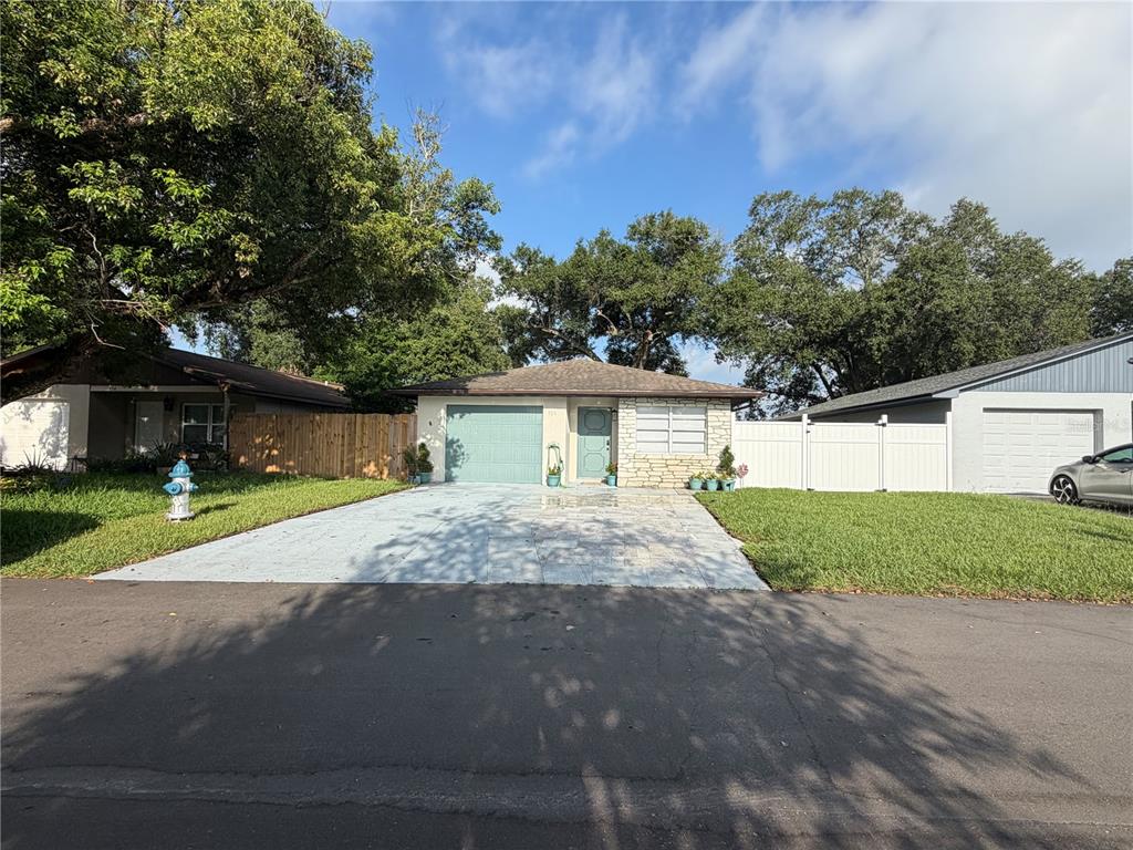 A living room with a white sectional sofa, glass coffee table, and an adjacent kitchen — 536 HIBISCUS WAY UNIT 7B, ORLANDO, FL