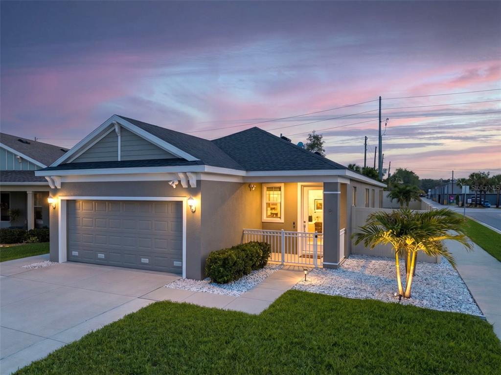 A covered patio features outdoor furniture, potted plants, and a concrete floor under a blue sky — 1461 N RIVER CIRCLE, TARPON SPRINGS, FL