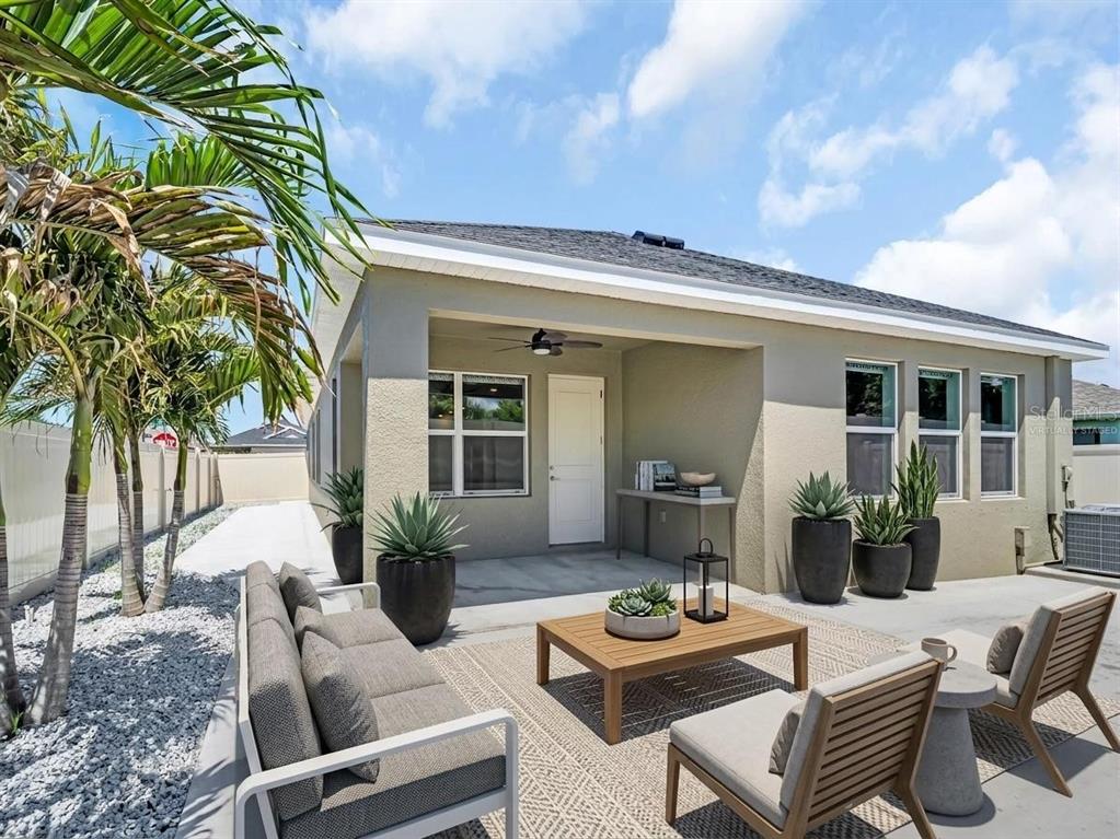 An open-concept living and dining area features a gray sectional, marble coffee table, and kitchen — 1461 N RIVER CIRCLE, TARPON SPRINGS, FL