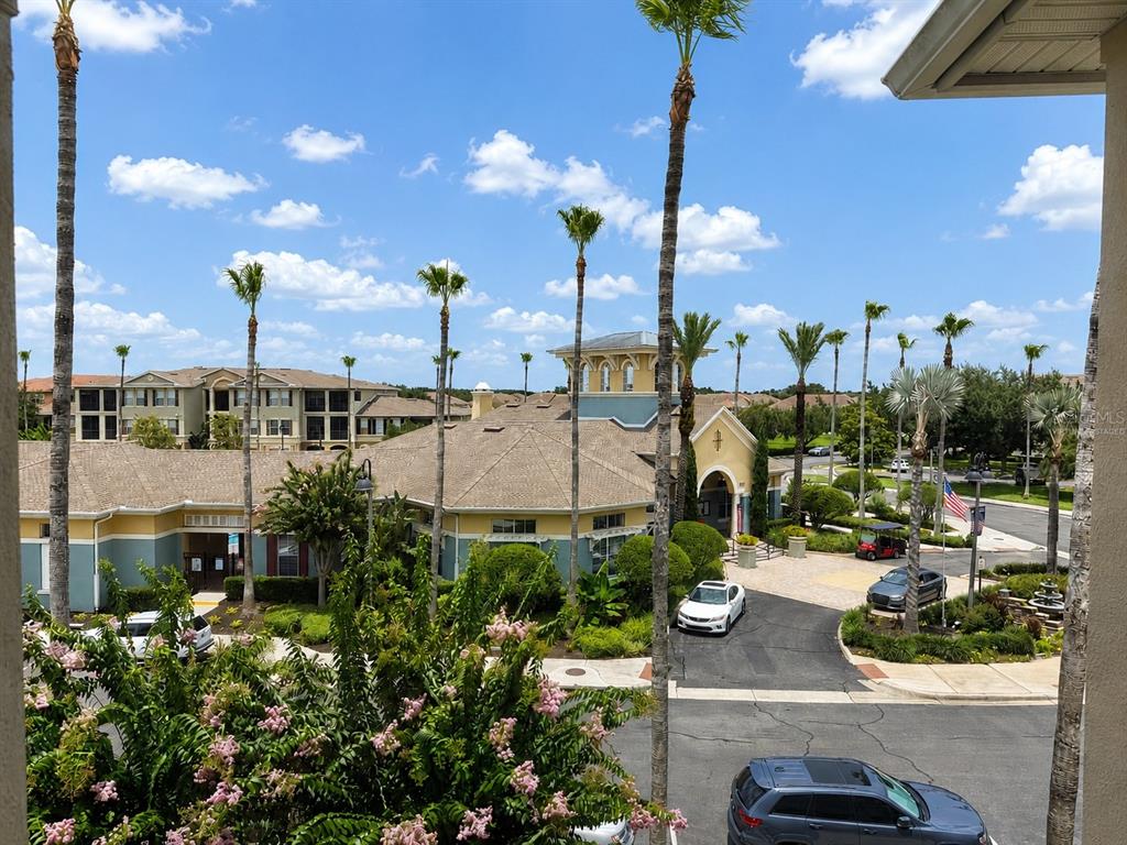 An elevated view of a community clubhouse, parking area, and surrounding palm trees — 8168 BOAT HOOK LOOP UNIT 724, WINDERMERE, FL
