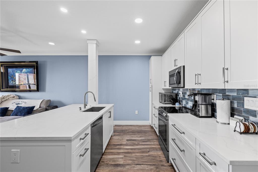 A balcony with two blue chairs overlooks a body of water and lush green trees — 5000 CULBREATH KEY WAY UNIT 9-216, TAMPA, FL