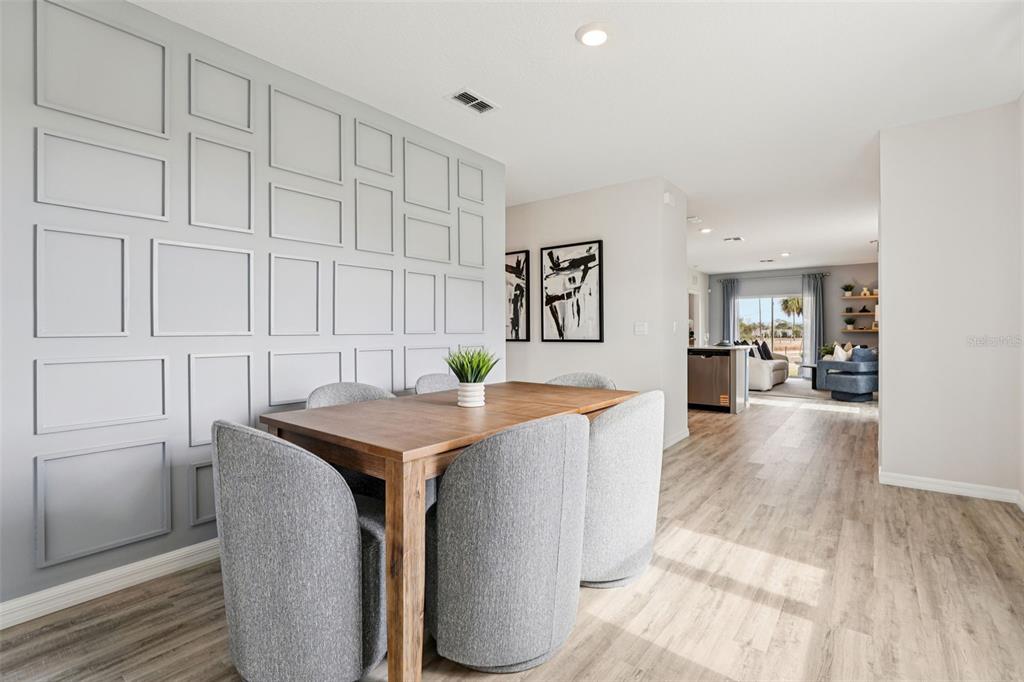 A dining area features a wooden table, gray upholstered chairs, and a paneled accent wall — 4049 GIORGIO DRIVE, WINTER HAVEN, FL