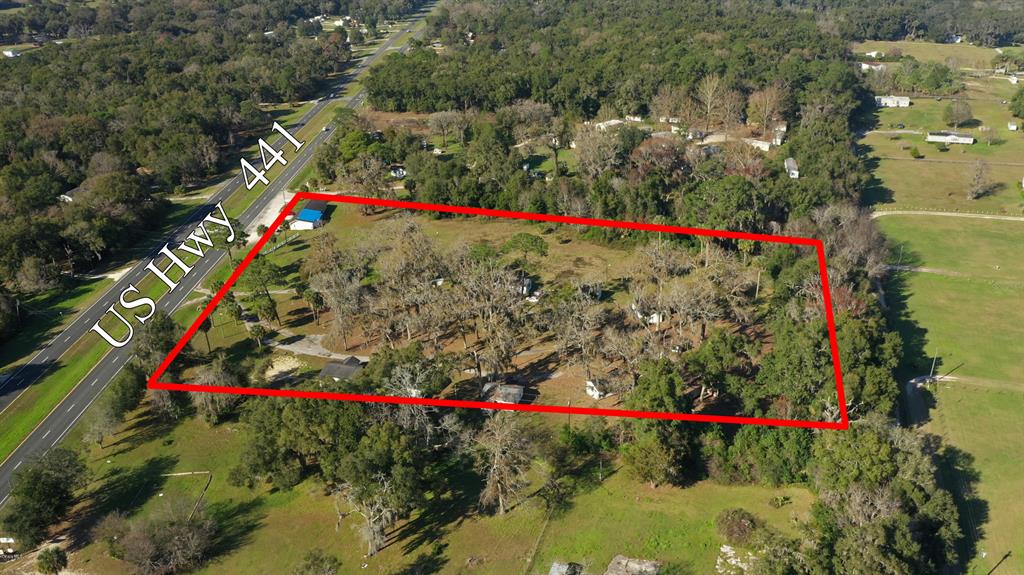 An aerial view shows a rectangular plot of land outlined in red beside a highway — 18585 N HIGHWAY 441, REDDICK, FL