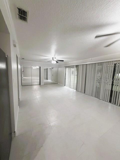 A spacious room features white tile flooring, a ceiling fan, and mirrored closet doors — 280 MOREE LOOP UNIT 2, WINTER SPRINGS, FL