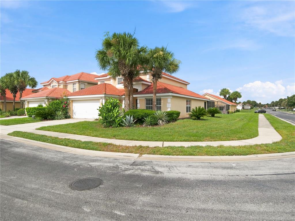A two-story house with a red tile roof and a white garage sits on a corner — 1153 SOLANA CIRCLE, DAVENPORT, FL