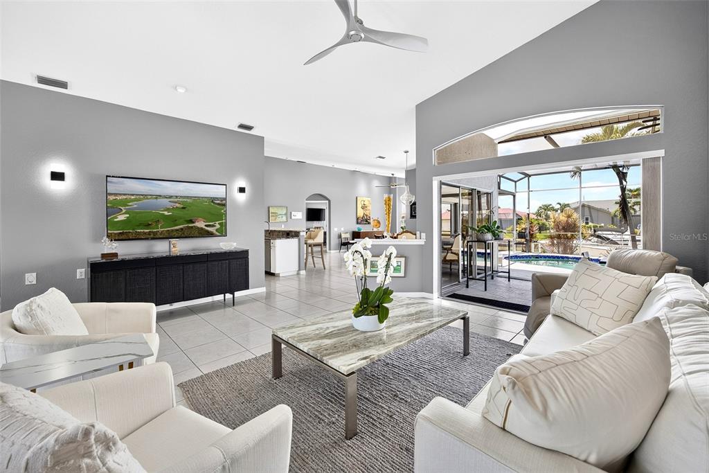 A living room features light tile floors, a marble coffee table, and sliding glass doors — 1552 AQUI ESTA DRIVE, PUNTA GORDA, FL