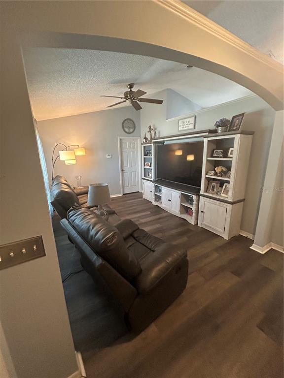 A living room features dark wood flooring, a large entertainment center, and leather reclining furniture — 3243 BRETTON WOODS TERRACE, DELTONA, FL