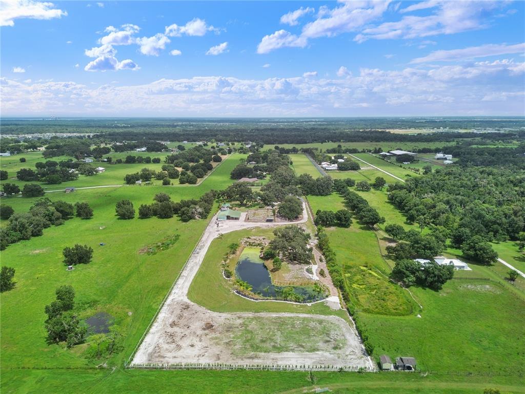 A blue Adirondack chair sits on a wooden dock overlooking a small pond — 5925 SPENCER PARRISH ROAD, PARRISH, FL