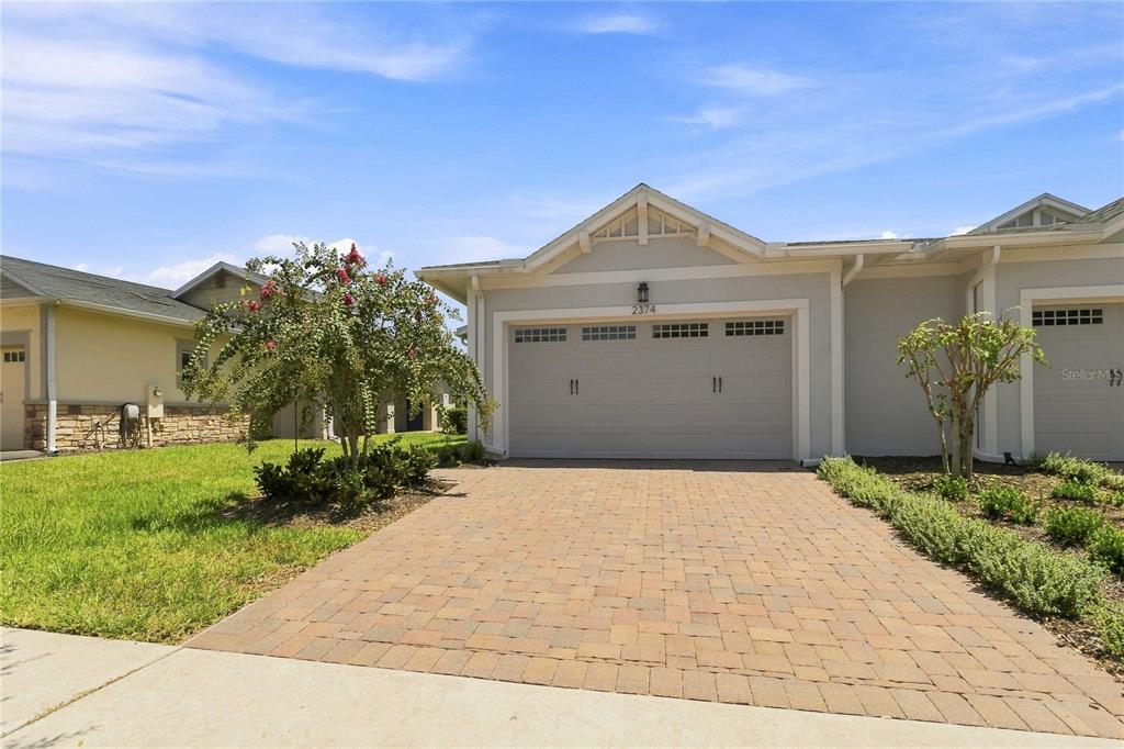 A single-story house with a paved driveway, a two-car garage, and a small front yard — 2374 DATURA LOOP, ST CLOUD, FL