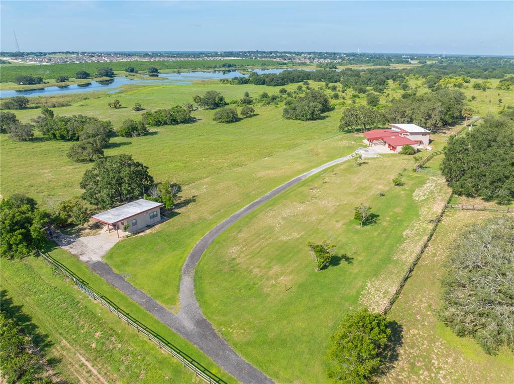 A single-story house with a flat roof, red trim, sliding glass doors, and a garage — 2741 EDWARDS ROAD, HAINES CITY, FL