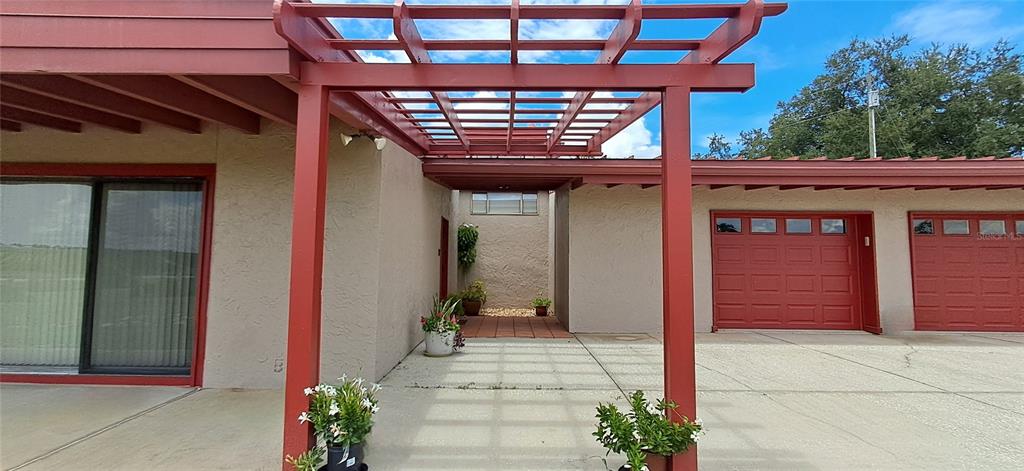 A two-story house with a red roof and a concrete patio overlooks a grassy field — 2741 EDWARDS ROAD, HAINES CITY, FL