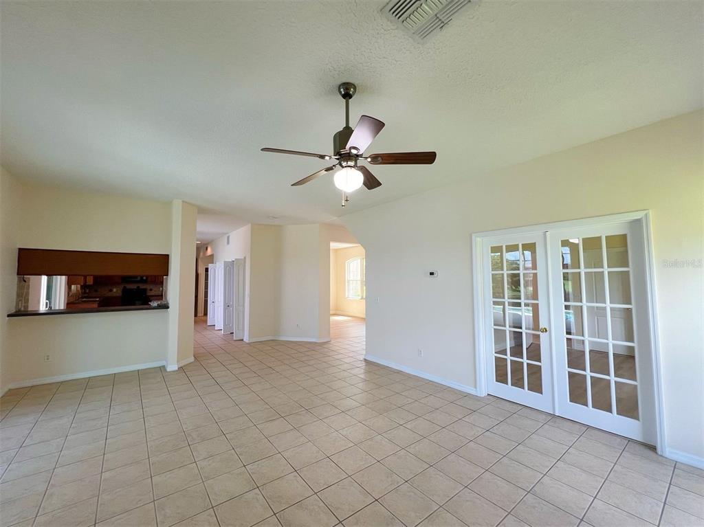 A living room with tile flooring, a ceiling fan, and white French doors — 2716 GORST RD, WINTER GARDEN, FL